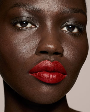 deep skin toned model wearing stunna lip paint in the shade uncensored