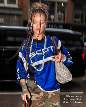 Paparazzi photo of Rihanna wearing Gloss Bomb Stix lip gloss stick in shade 'Is It Fu$$y'.