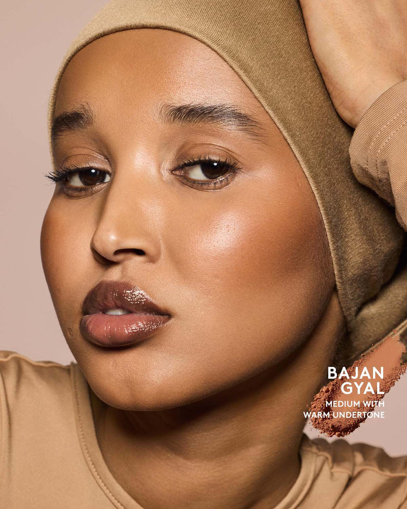 Medium skin tone model wearing sun stalk'r bronzer in shade Bajan Gyal.