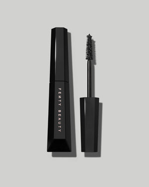An open Fenty Hella Thicc mascara tube on a grey background.