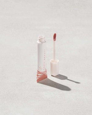 Open tube of Pro Kiss'r Luscious Lip Balm in shade Latte Lips on grey background.