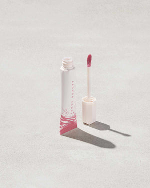 Open tube of Pro Kiss'r Luscious Lip Balm in shade Pinch Me on grey background.